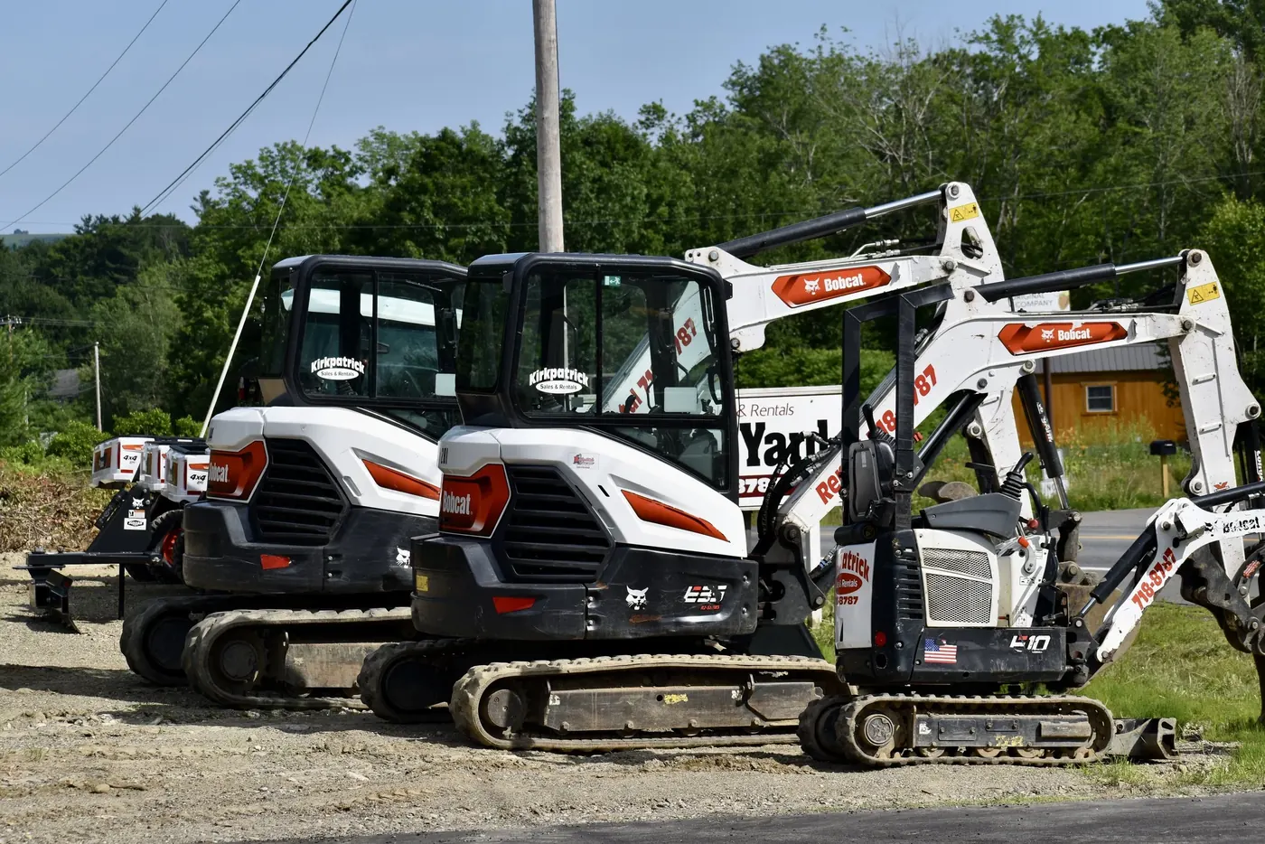 A row of compact Bobcat excavators lined up in the Kirkpatrick rental yard.
